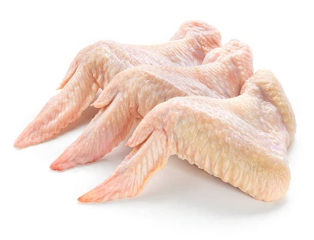 Alitas de pollo crudas sobre fondo blanco