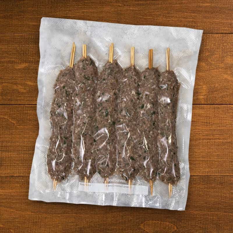Brochetas de carne picada cruda sobre papel de horno