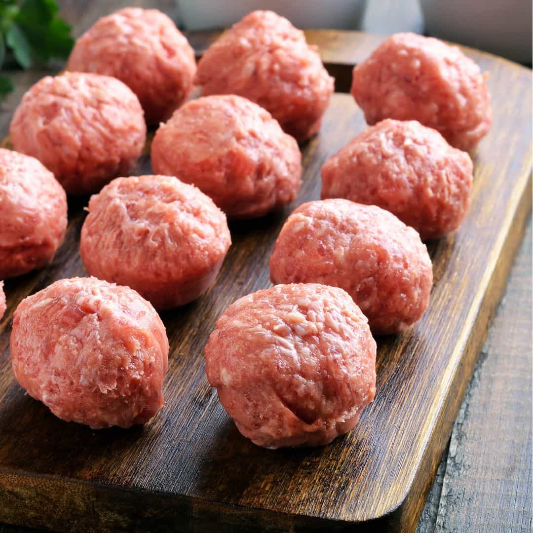 Albóndigas crudas colocadas sobre una tabla de madera