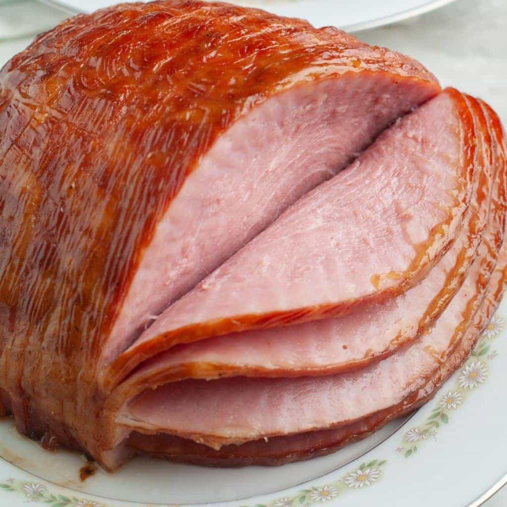 Jamón ahumado rebanado en espiral sobre un plato de servir